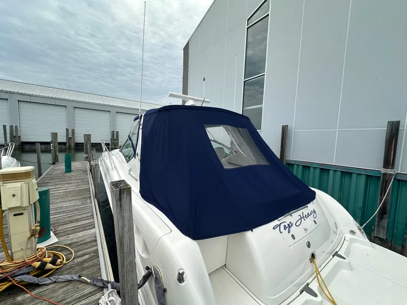 Slide: The Image of 2003 Sea Ray 420 Sundancer docked, featuring a blue canvas cover and "Top Heavy" name. - 6