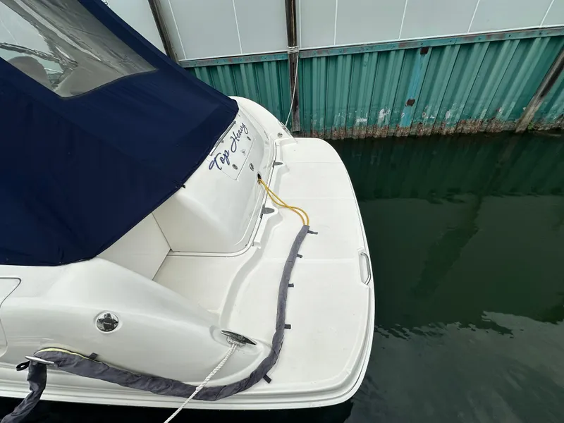Slide: The Image of 2003 Sea Ray 420 Sundancer docked, featuring a blue canopy and white deck. - 7