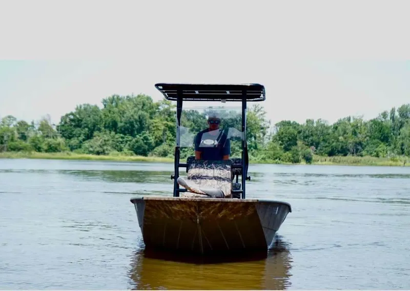Slide: The Image of Man operating 2023 G3 Bay 20 GX boat on a calm river. - 4
