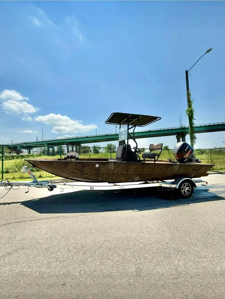 Slide: The Image of 2023 G3 Bay 20 GX boat on trailer, parked outdoors under clear blue sky. - 5