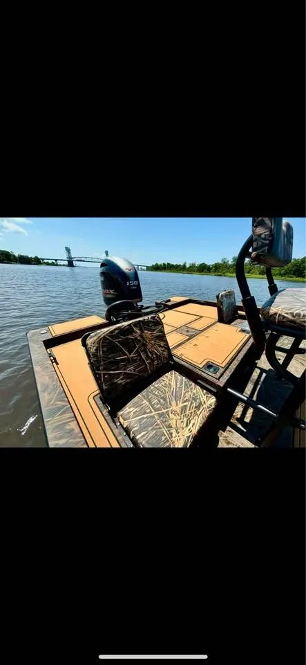 Slide: The Image of 2023 G3 Bay 20 GX boat on a river, featuring camo seats and a powerful outboard motor. - 6