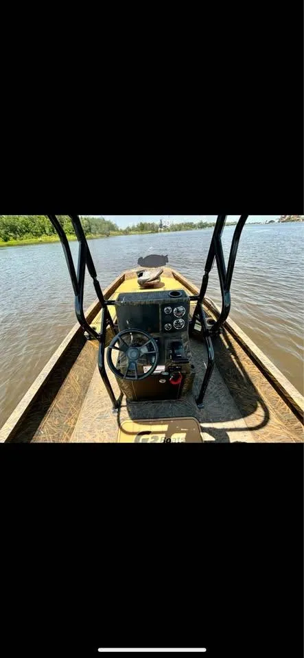 Slide: The Image of 2023 G3 Bay 20 GX boat on a calm river, featuring a central steering console. - 8