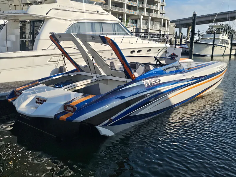 Slide: The Image of 2010 Daves Custom Boats M35 on trailer, vibrant blue and orange design, rear view. - 13