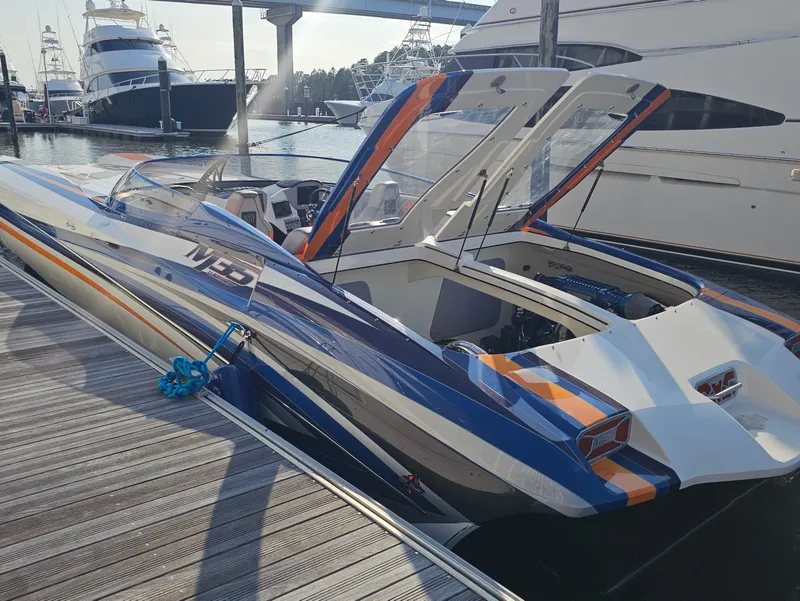 Slide: The Image of 2010 Daves Custom Boats M35 with colorful stripes, covered and parked in a marina. - 15