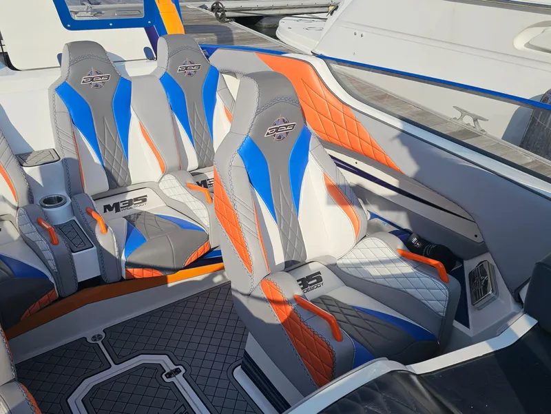 Slide: The Image of 2010 Daves Custom Boats M35 interior with vibrant blue, orange, and gray seating design. - 30