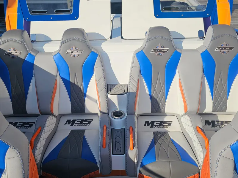 Slide: The Image of 2010 Daves Custom Boats M35 with vibrant blue and orange seating at a marina. - 32