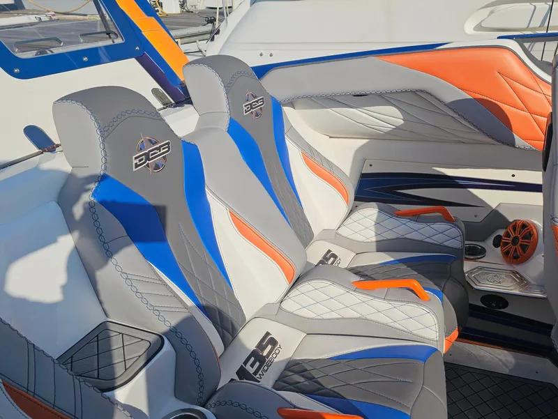 Slide: The Image of Interior of a 2010 Daves Custom Boats M35 with vibrant blue and orange seating. - 33