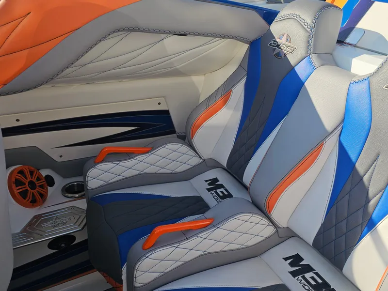 Slide: The Image of 2010 Daves Custom Boats M35 interior with vibrant blue and orange seating at a dock. - 34