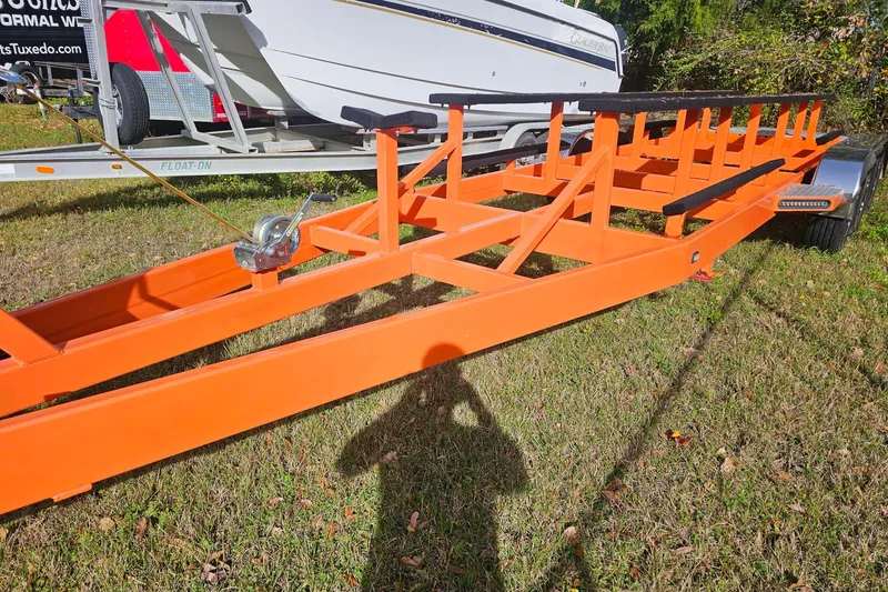 Slide: The Image of Orange boat trailer for 2010 Daves Custom Boats M35 on grassy area. - 54