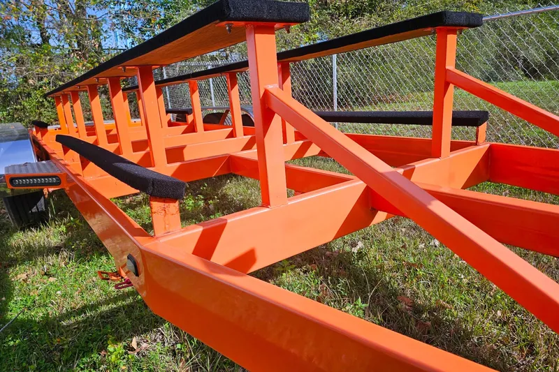 Slide: The Image of Orange boat trailer for 2010 Daves Custom Boats M35, parked on grass. - 55