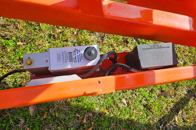 Slide: The Image of Orange frame with brake actuator on 2010 Daves Custom Boats M35, resting on grass. - 59