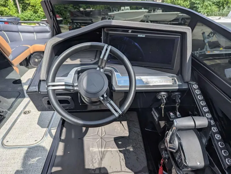 Slide: The Image of 2025 Berkshire 25 Sport RFX9-DC boat dashboard with steering wheel and control panel. - 17