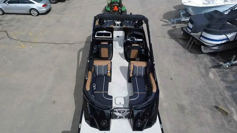 Slide: The Image of 2025 Berkshire 25 Sport RFX9-DC pontoon boat with luxurious seating, parked in a lot. - 6