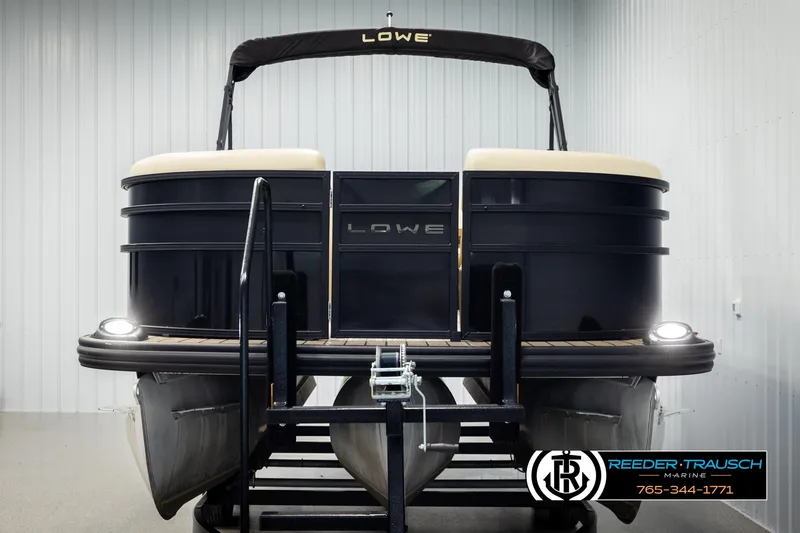 Slide: The Image of 2023 Lowe 210 SSTL pontoon boat in showroom, front view with lights on. - 8