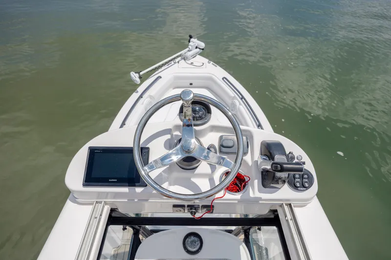 Slide: The Image of 2015 Everglades 243 Center Console boat helm with steering wheel and controls on water. - 16