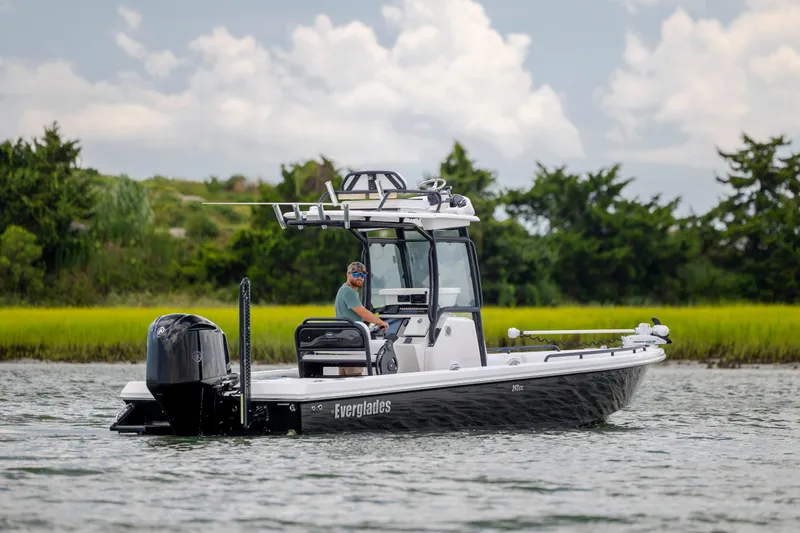 Slide: The Image of 2015 Everglades 243 Center Console boat on water, with lush greenery in the background. - 6
