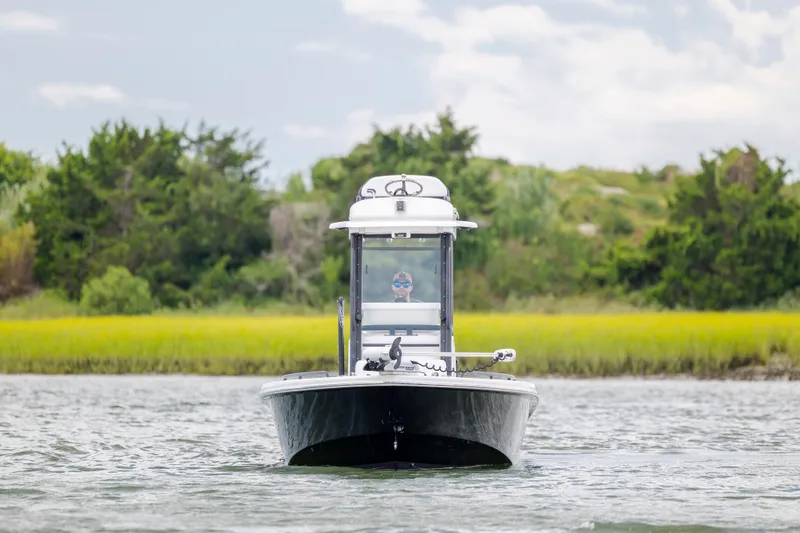 Slide: The Image of 2015 Everglades 243 Center Console boat on water, lush greenery in background. - 7