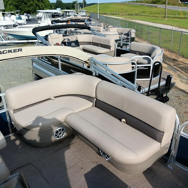 Slide: The Image of 2025 Sun Tracker Bass Buggy 16 XL Select pontoon boat with beige seating, docked outdoors. - 10