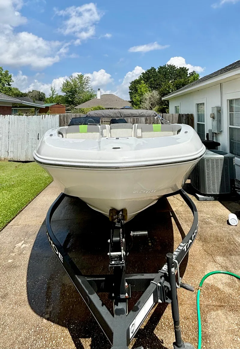 Slide: The Image of 2022 Tahoe T18 boat on trailer in driveway, sunny day, residential background. - 2