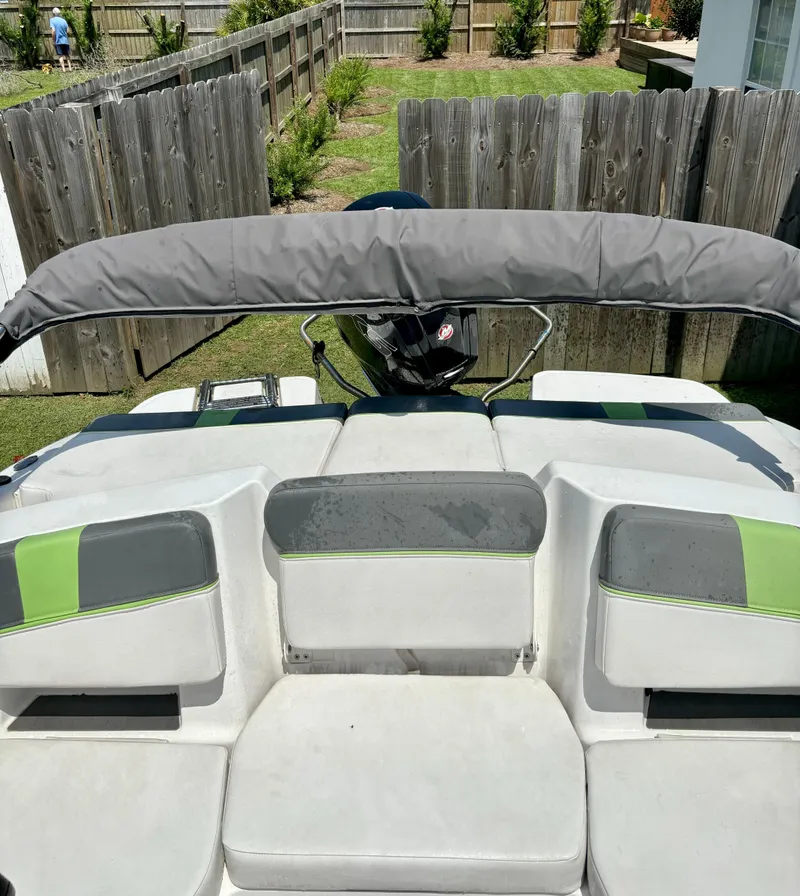 Slide: The Image of 2022 Tahoe T18 boat with gray and green seating, parked in a backyard. - 4