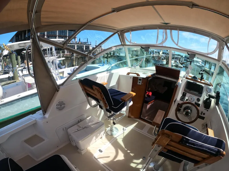 Slide: The Image of 2005 Hunt Yachts Surfhunter 25 cockpit with helm, seating, and marina view. - 10