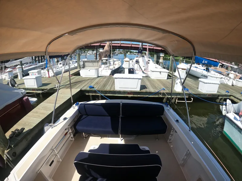 Slide: The Image of 2005 Hunt Yachts Surfhunter 25 at marina, featuring spacious seating and canopy. - 11