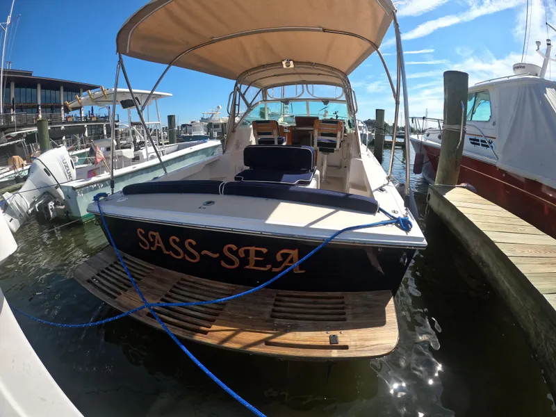 Slide: The Image of 2005 Hunt Yachts Surfhunter 25 docked, featuring "SASS-SEA" name, with canopy and seating. - 15