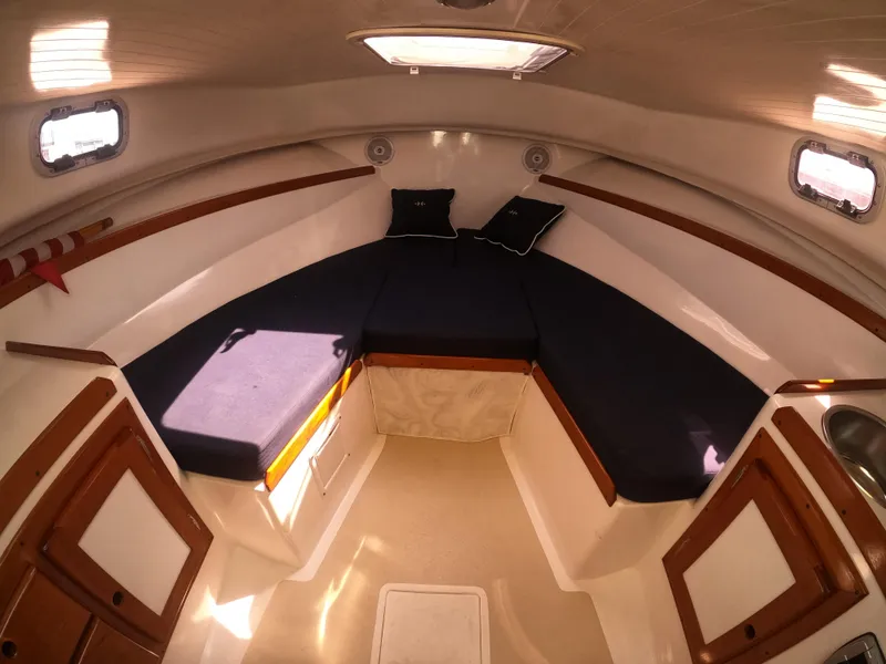 Slide: The Image of 2005 Hunt Yachts Surfhunter 25 cabin interior with cozy seating and wooden accents. - 22