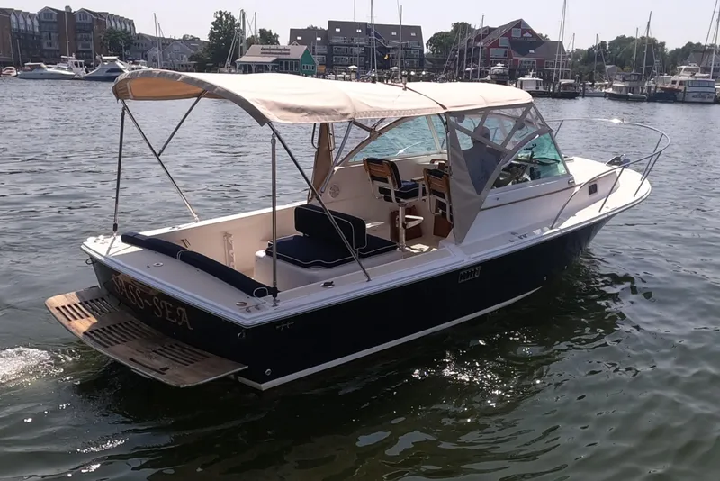 Slide: The Image of 2005 Hunt Yachts Surfhunter 25 boat on water, featuring a canopy and open deck. - 3