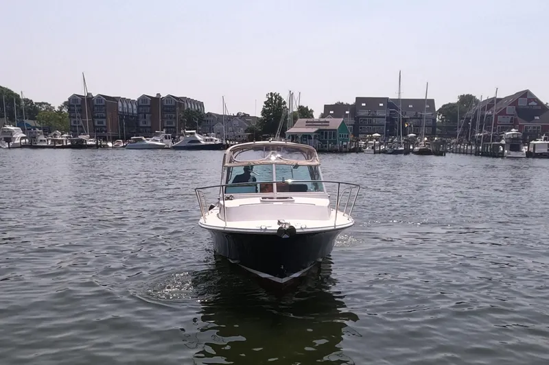 Slide: The Image of 2005 Hunt Yachts Surfhunter 25 on calm water near a marina. - 4