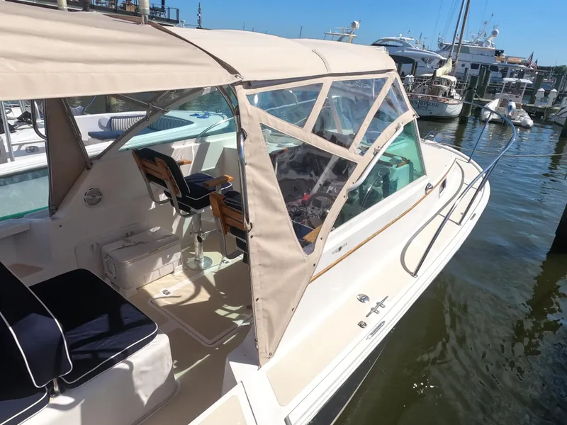 Slide: The Image of 2005 Hunt Yachts Surfhunter 25 docked, featuring beige canopy and sleek design. - 18