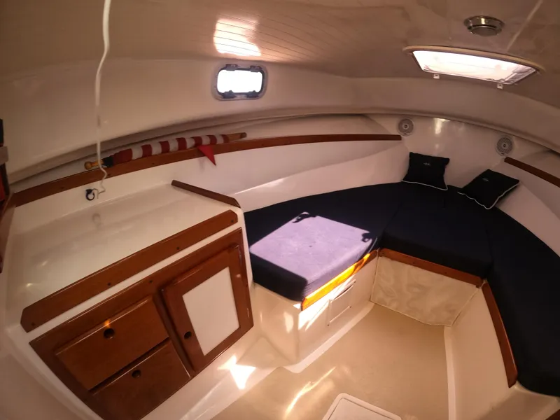 Slide: The Image of 2005 Hunt Yachts Surfhunter 25 cabin interior with cozy seating and wooden cabinetry. - 21