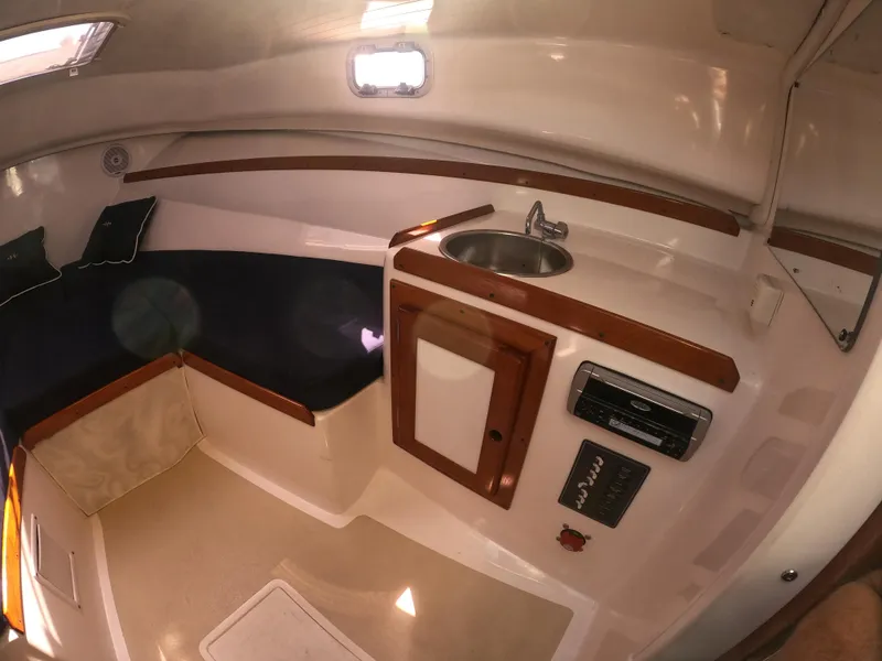 Slide: The Image of 2005 Hunt Yachts Surfhunter 25 cabin interior with seating and compact kitchenette. - 23