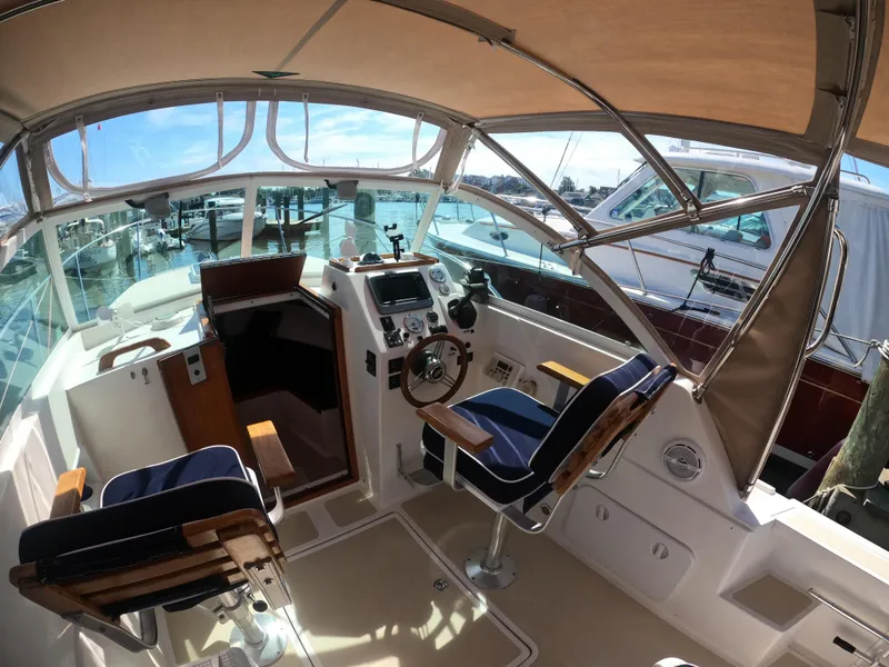 Slide: The Image of 2005 Hunt Yachts Surfhunter 25 cockpit with helm, seating, and marina view. - 8