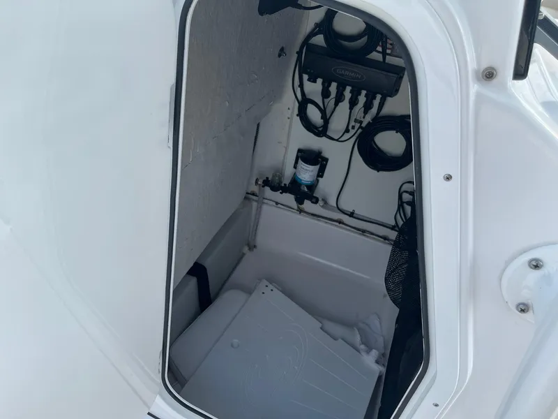 Slide: The Image of 2021 Sportsman Heritage 211 Center Console storage compartment with wiring and equipment. - 13