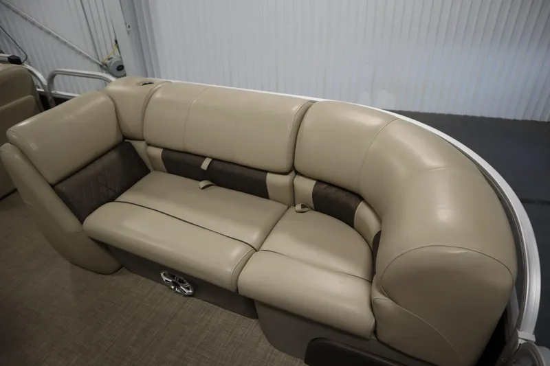 Slide: The Image of 2023 Tracker 20 DLX PARTY BARGE beige seating with brown accents, indoor setting. - 12