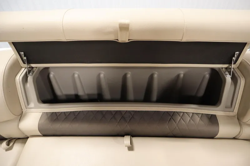 Slide: The Image of 2023 Tracker 20 DLX PARTY BARGE storage compartment with open lid, beige upholstery. - 18
