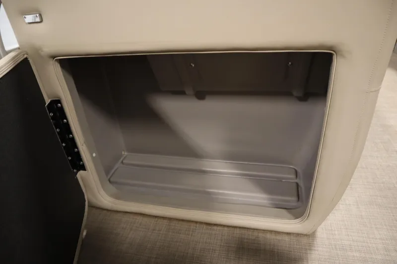 Slide: The Image of 2023 Tracker 20 DLX PARTY BARGE storage compartment, beige interior, open door view. - 21