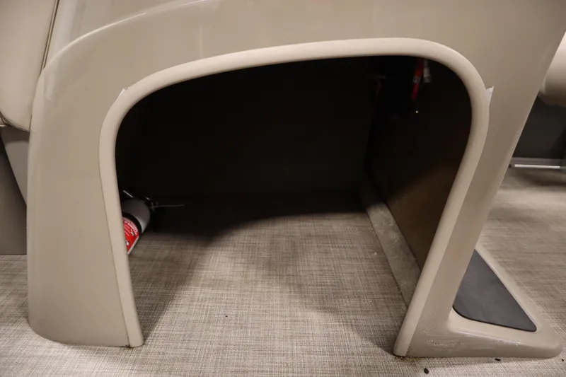 Slide: The Image of 2023 Tracker 20 DLX PARTY BARGE storage compartment with fire extinguisher on carpeted floor. - 23