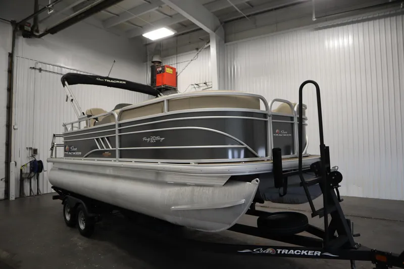 Slide: The Image of 2023 Tracker 20 DLX PARTY BARGE pontoon boat in indoor storage. - 3