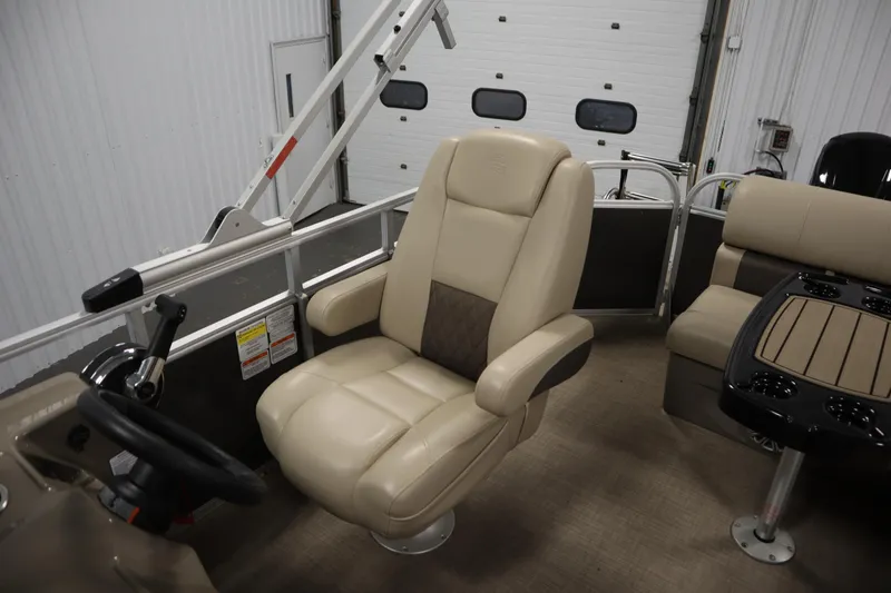 Slide: The Image of 2023 Tracker 20 DLX PARTY BARGE interior with beige captain's chair and table. - 31