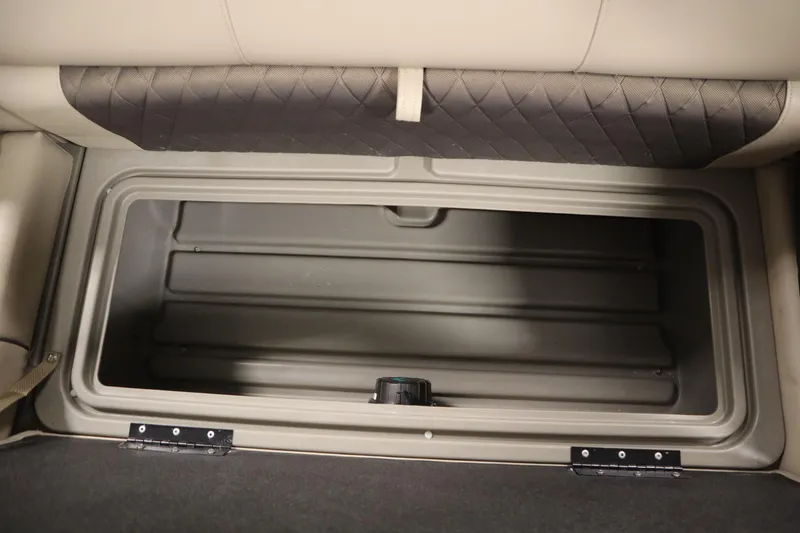 Slide: The Image of 2023 Tracker 20 DLX PARTY BARGE storage compartment, open and empty, with beige seating above. - 35