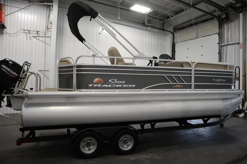 Slide: The Image of 2023 Tracker 20 DLX PARTY BARGE pontoon boat in a garage setting. - 4