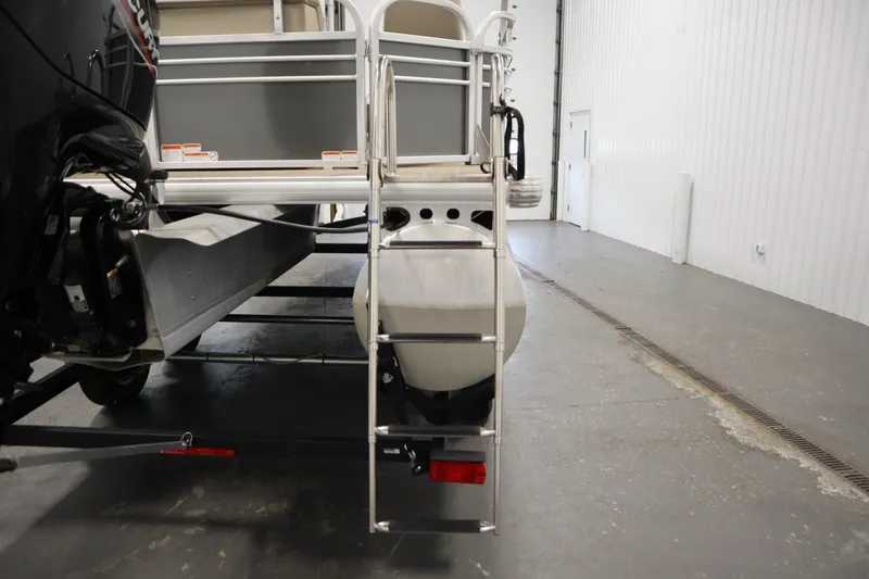 Slide: The Image of 2023 Tracker 20 DLX PARTY BARGE pontoon boat with ladder in a warehouse setting. - 41