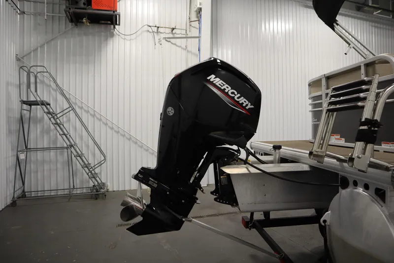 Slide: The Image of 2023 Tracker 20 DLX PARTY BARGE with Mercury outboard motor in a storage facility. - 43