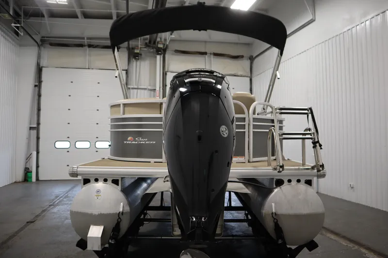 Slide: The Image of 2023 Tracker 20 DLX PARTY BARGE pontoon boat in a garage setting. - 6