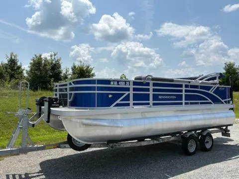 The Image of 2024 Bennington 20SVF pontoon boat on trailer under a partly cloudy sky. - 1