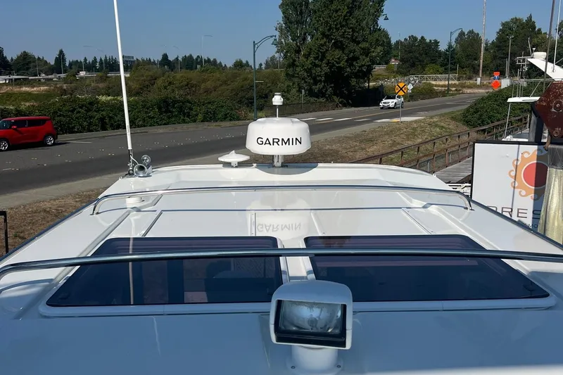 Slide: The Image of 2023 Jeanneau NC Weekender 1095 boat with Garmin radar on deck, parked near road. - 18