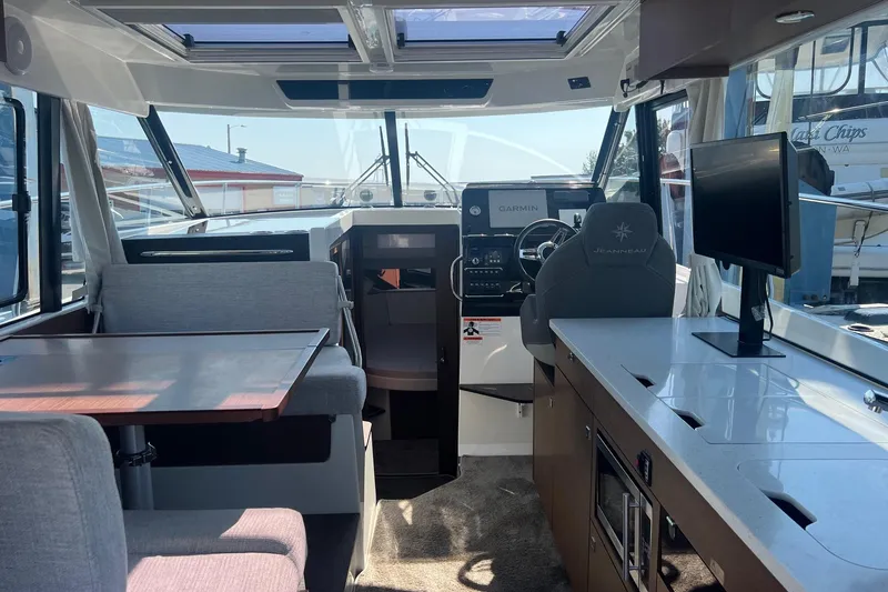 Slide: The Image of Interior of 2023 Jeanneau NC Weekender 1095, featuring helm, seating, and modern amenities. - 24