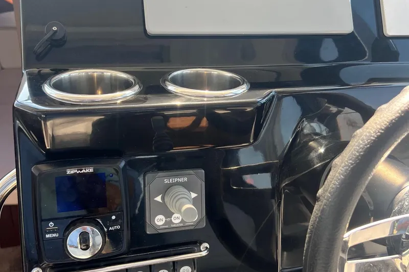 Slide: The Image of 2023 Jeanneau NC Weekender 1095 dashboard with controls and cup holders. - 25
